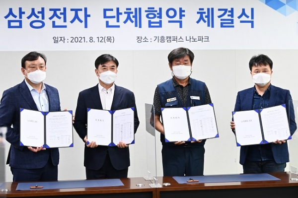 ▲삼성전자와 삼성전자노동조합 공동교섭단이 지난 12일 오후 삼성전자 기흥캠퍼스에서 단체협약 협약식을 마친 뒤 기념촬영을 하고 있다. 왼쪽부터 최완우 삼성전자 DS부문 인사팀장, 김현석 삼성전자 대표이사, 김만재 한국노동조합총연맹 전국금속노동조합연맹 위원장, 김항열 삼성전자사무직노동조합 위원장.