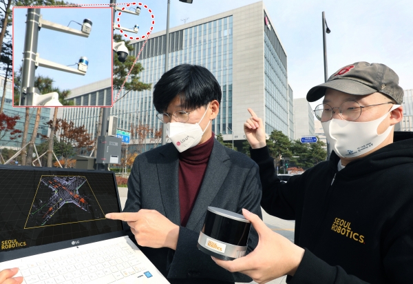 LG유플러스 서울 마곡사옥 앞 교차로에 설치된 LiDAR 센서를 주영준 LG유플러스 차세대기술Lab장(왼쪽)과 이한빈 서울로보틱스 대표가 살펴보고 있는 모습./사진=LG유플러스