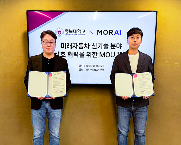 ▲충북대학교 미래자동차혁신융합대학사업단 김곤우 사업단장(왼쪽)과 모라이 홍준 대표가 MOU 체결 후 기념 촬영을 하고 있다.