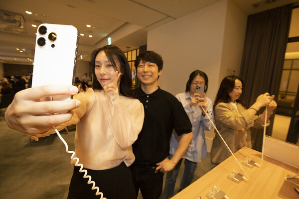 서울 강남 안다즈 호텔에서 열린 KT 아이폰16 개통 행사의 전시 공간에서 고객들이 아이폰16을 체험하고 있다.