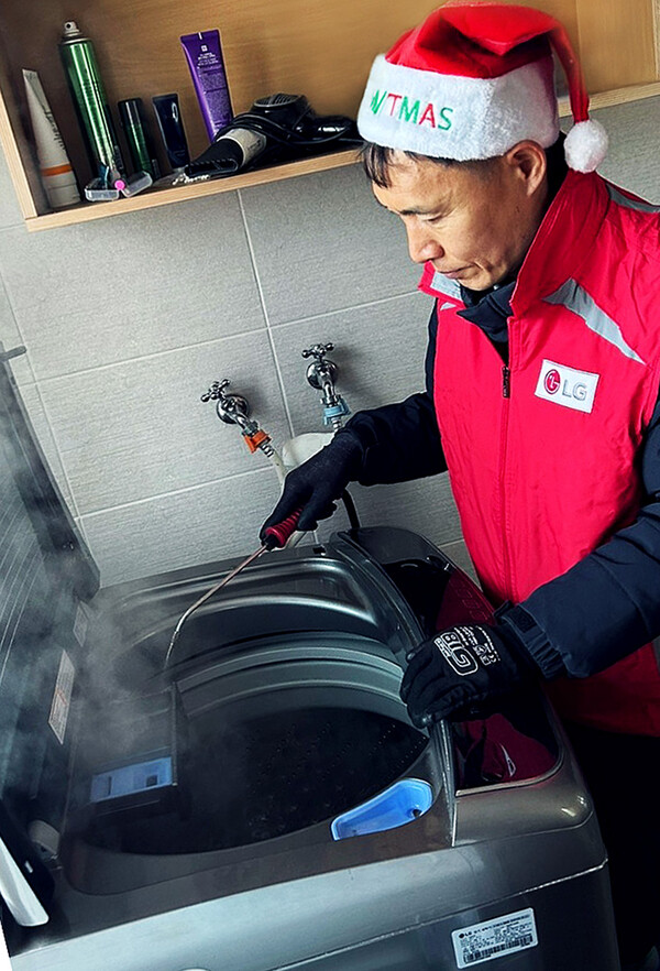 ▲LG전자 서비스 매니저가 복지시설을 찾아 겨울철 동결·동파가 발생하기 쉬운 세탁기를 점검하고 스팀으로 내부를 살균하고 있다.
