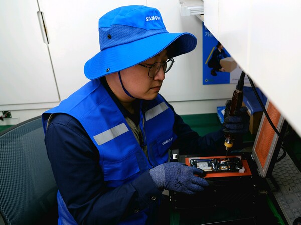 ▲삼성전자서비스 재난복구특별서비스팀 직원이 지난 3월 28일 경북 의성 실내체육관에 마련된 이재민 대피소에서 산불 피해 주민의 휴대전화를 무상 수리하고 있다. 