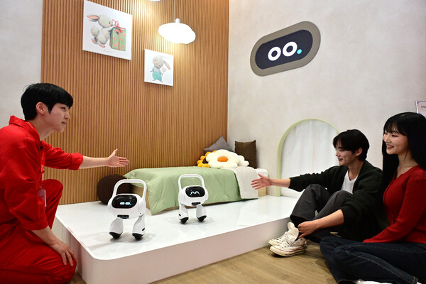 ▲LG전자가 국내 최대 정보통신기술 전시회 '월드IT 쇼 2025'에 참가해 공감지능(AI)을 통해 변화하는 고객의 공간과 일상을 선보인다. 모델이 LG전자 직원에게 고객의 목소리와 표정·말투로 감정까지 파악하는 이동형 AI홈(프로젝트명 : Q9)의 설명을 듣고 있다.